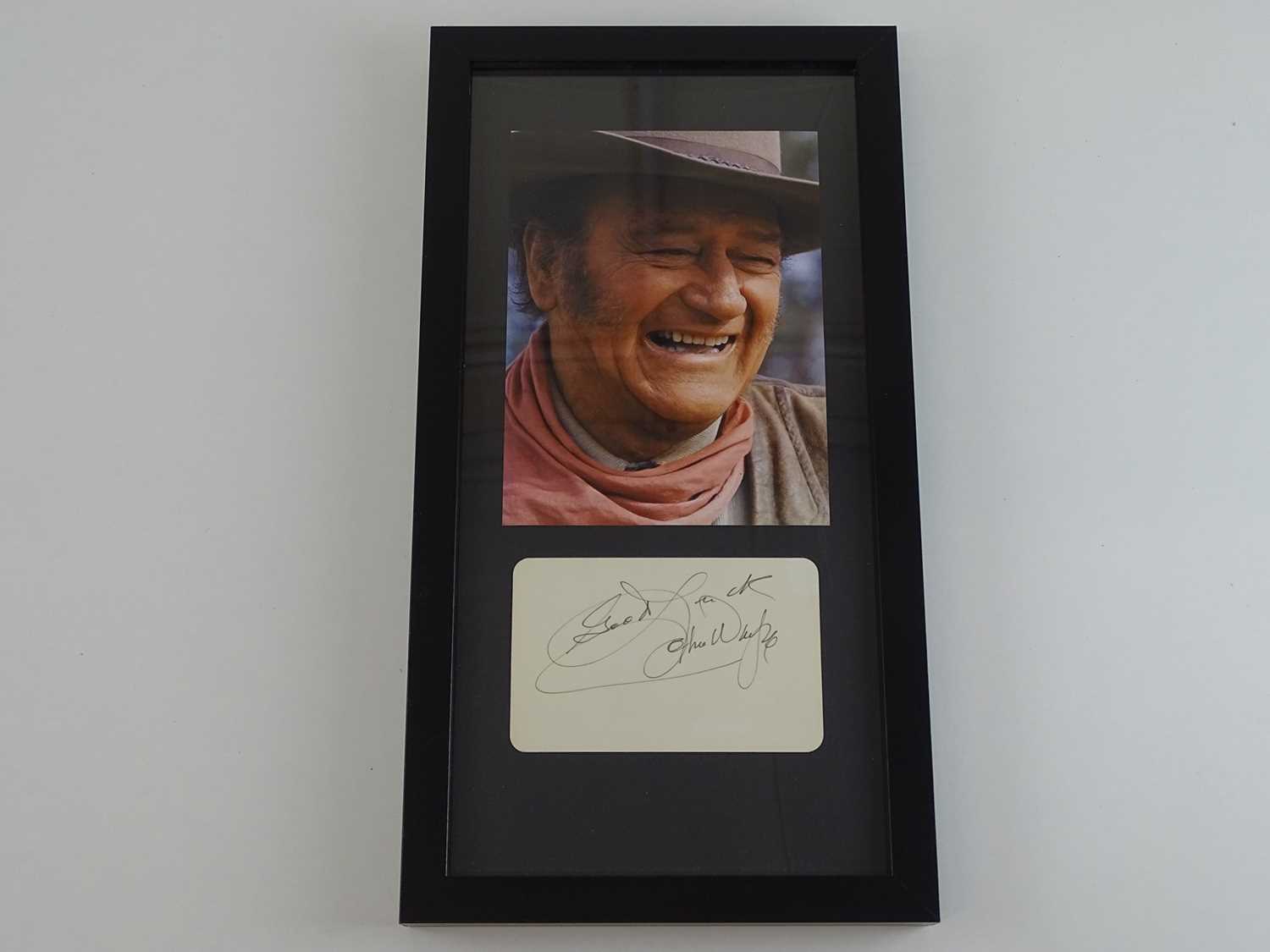 Lot 211 - JOHN WAYNE: A framed and glazed display of...