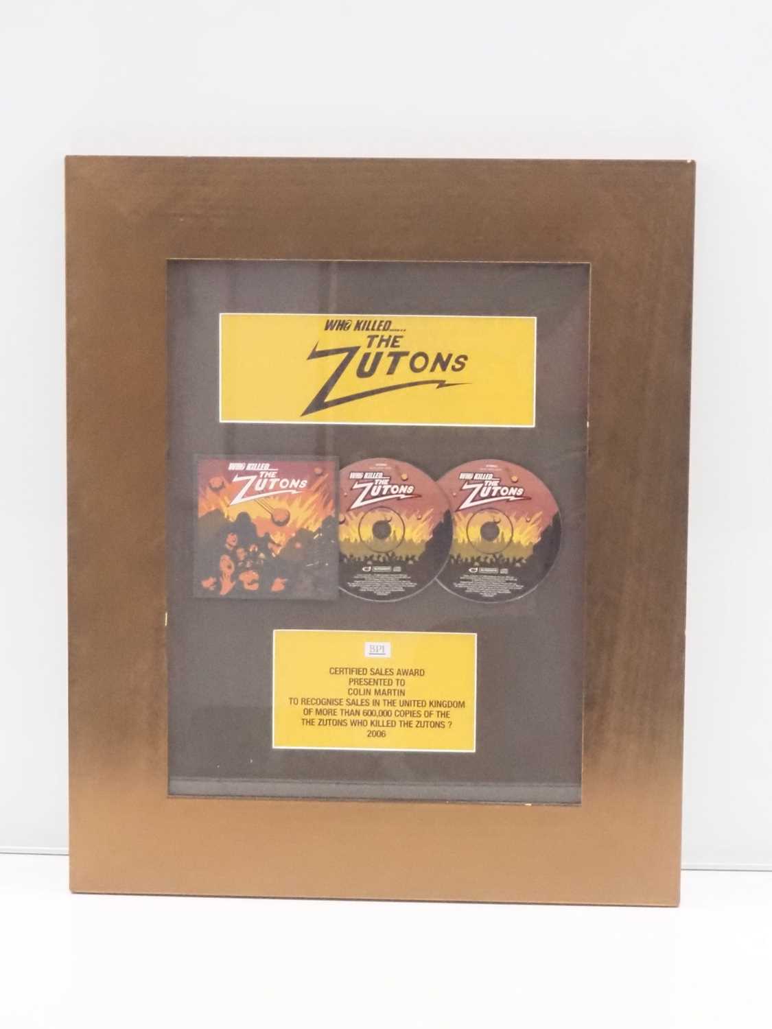 Lot 689 ZUTONS A framed and glazed BPI award for