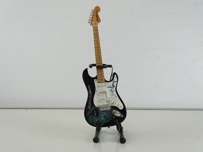 Lot 126 - A mini model guitar with stand signed to the...