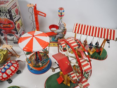 Lot 490 - A group of boxed and unboxed tinplate toys,...
